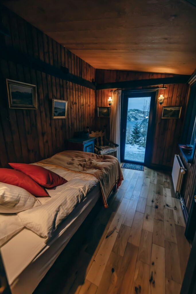 Cosy wooden cottage room with bed and balcony door